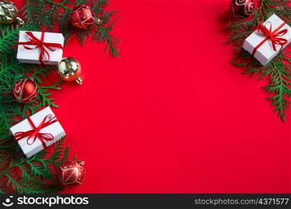 Gift boxes and festive decor. Christmas composition on red background. Place for text.. Gift boxes and festive decor. Christmas composition on red background.