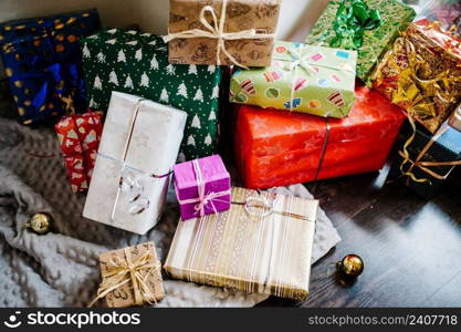 Gift boxes with ornaments on brown wooden, gray knitted background. space for text, design. Happy Holidays. top view. stylish wrapped gifts. merry christmas, new year concept. birthday.