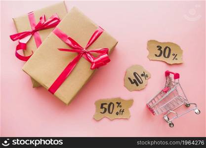 gift boxes with red bows near shopping trolley. High resolution photo. gift boxes with red bows near shopping trolley. High quality photo