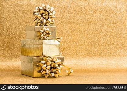 Gift boxes with ribbon bow on golden shiny background. Holidays decoration. Greetings card concept