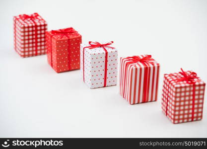 Gift boxes with xmas presents wrapped in red paper with ornament on white background. Lots of copyspace