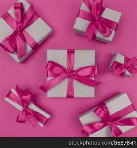 Gift boxes wrapped in a craft paper with pink ribbons and bows. Festive monochrome flat lay.. Gift boxes wrapped in craft paper with pink ribbons and bows. Festive monochrome flat lay.