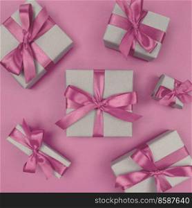 Gift boxes wrapped in a craft paper with soft pink ribbons and bows. Festive monochrome flat lay.. Gift boxes wrapped in craft paper with soft pink ribbons and bows. Festive monochrome flat lay.