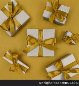 Gift boxes wrapped in a craft paper with yellow ribbons and bows. Festive monochrome flat lay.. Gift boxes wrapped in craft paper with yellow ribbons and bows. Festive monochrome flat lay.