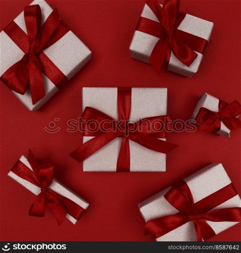 Gift boxes wrapped in craft paper with a red ribbons and bows. Festive monochrome flat lay.. Gift boxes wrapped in craft paper with red ribbons and bows. Festive monochrome flat lay.