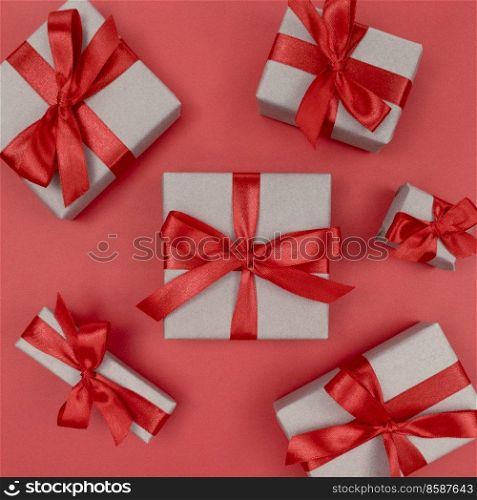 Gift boxes wrapped in craft paper with red ribbons and bows. Festive monochrome flat lay. Gift boxes wrapped in craft paper with red ribbons and bows. Festive monochrome flat lay.