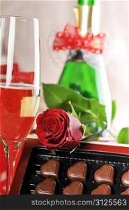 gift, champagne and red rose close-up