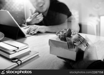 Gift Giving.business creative designer hand giving his colleague Christmas present in office,black white