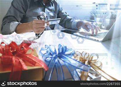 Gift giving,medical doctor Hand with credit card and hand with gift. Gift delivery, surprise,laptop computer and smart phone on mable desk,filter film effect