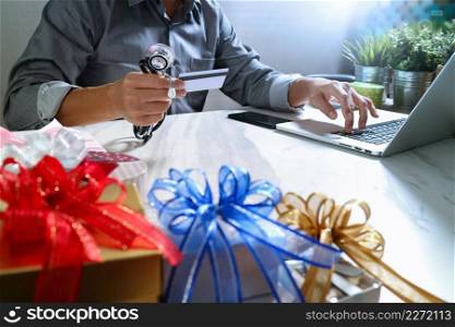 Gift giving,medical doctor Hand with credit card and hand with gift. Gift delivery, surprise,laptop computer and smart phone on mable desk,filter film effect