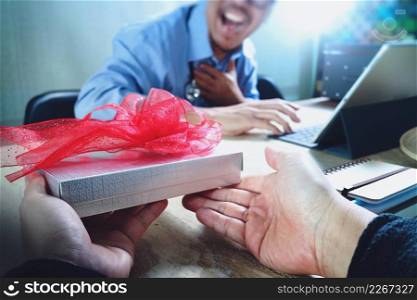 Gift Giving.Patient hand or Team giving a gift to a surprised Medical Doctor in hospital office,filter film effect