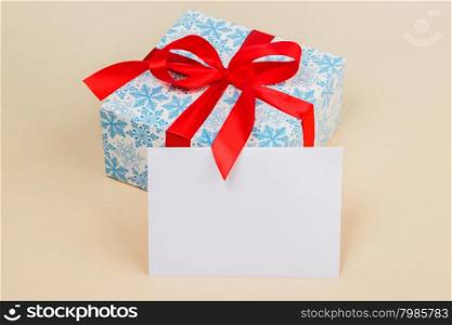 Gift in a beautiful package with a red ribbon. Gift in a beautiful package with a red ribbon and white card