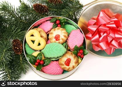 Gift of homemade Christmas cookies in a decorative tin, under the Christmas tree.