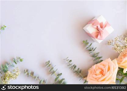 gift or present box and flowers. gift or present box and fresh rose flowers on blue table from above