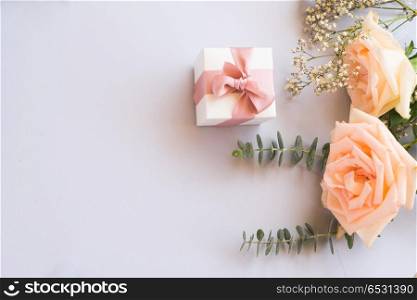 gift or present box and flowers. gift or present box and rose flowers on blue table from above