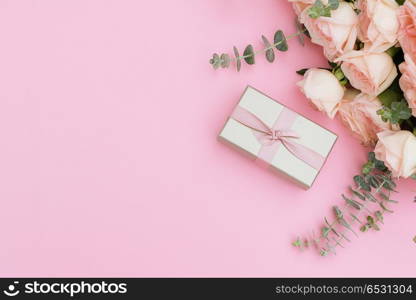 gift or present box and flowers on pink table from above, flat lay frame. gift or present box and flowers. gift or present box and flowers
