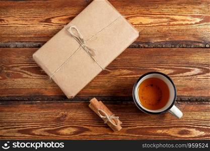 gift Packed in eco-friendly biodegradable cardboard and a glass of tea on a dark old wooden background with a blank space for text. top view. flat lay