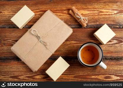 gift Packed in eco-friendly biodegradable cardboard and a glass of tea on a dark old wooden background with a blank space for text. top view. flat lay