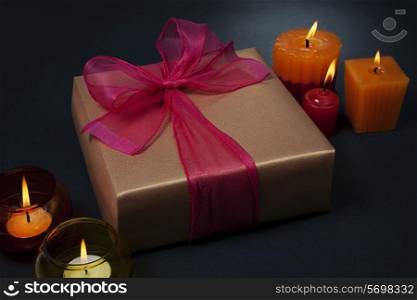 Gift surrounded by candles