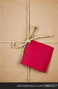Gift with red tag in brown paper