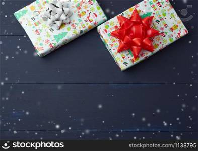 gift wrapped in multi-colored paper on a blue wooden background, festive backdrop, top view, copy space