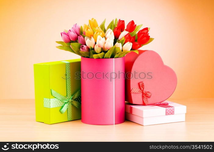 Giftbox and tulips against gradient background