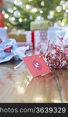 Gifts, unwrapped paper and gift tag on floor