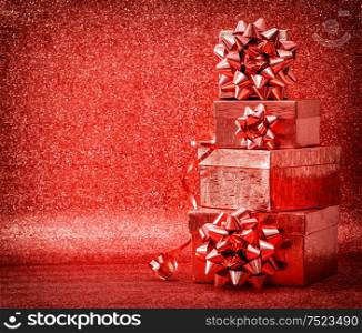 Gifts with ribbon bow on shiny red background. Holidays decoration
