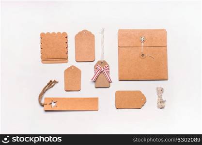 Gifts wrapping concept. Flat lay of various craft eco paper cardboard package and tags on white desktop background, top view.