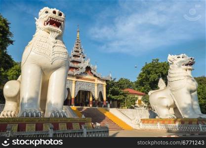 Gigantic Bobyoki Nat guardian statues at central entrance gate to Mandalay Hill Pagoda complex. Amazing architecture of Buddhist Temples in Myanmar (Burma). Travel landscapes and destinations