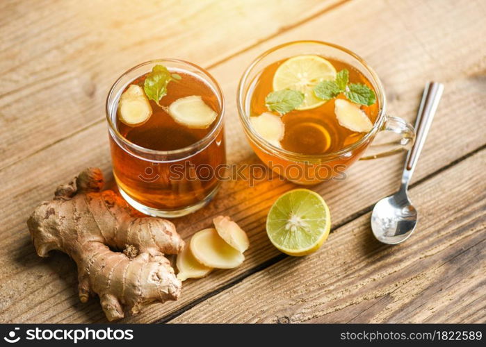 Ginger and lemon fresh cocktail, Hot ginger juice in glass and slices ginger root herbal juice tea