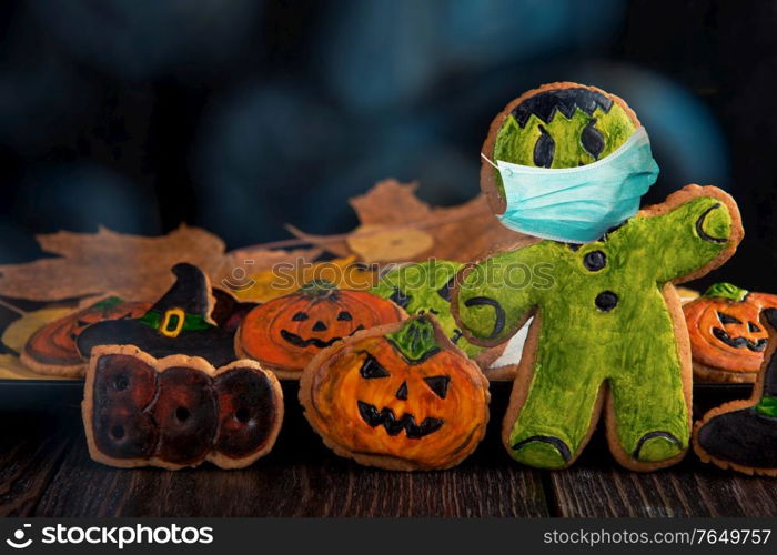 Ginger biscuits with face mask for Halloween holiday on wooden, concept of covid hallowen. concept of covid hallowen