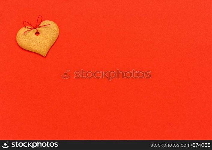 Ginger cookies heart-shaped decorated with a bow on a red background. Top view Copy space Valentine card.. Ginger cookies heart-shaped decorated with a bow on a red background. Top view Copy space Valentine card