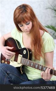 Ginger-haired girl playing guitar