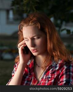 Ginger haired women on cell phone outdoors