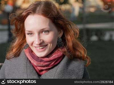 Ginger haired women smiling outdoors in autumn (fall) city park
