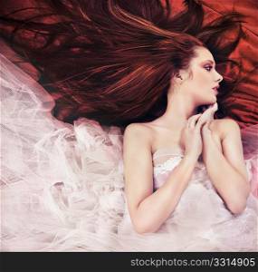 Ginger long haired young woman in sensual pose
