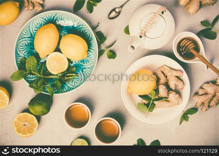 Ginger tea with lemon, honey and mint on grey concrete background. Top view, flat lay
