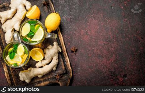 Ginger tea with mint and citrus. On rustic background.. Ginger tea with mint and citrus.