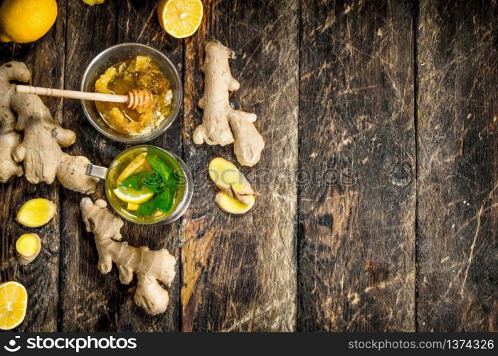 Ginger tea with mint and lemon. On wooden background.. Ginger tea with mint and lemon.