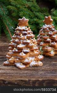 gingerbread christmas tree. Baked gingerbread christmas tree with fresh evergreen branches on wooden table