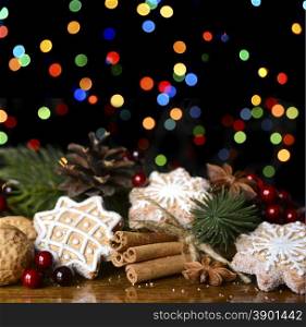 Gingerbread cookies and spruce branches on a wooden background