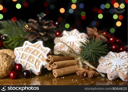Gingerbread cookies and spruce branches on a wooden background