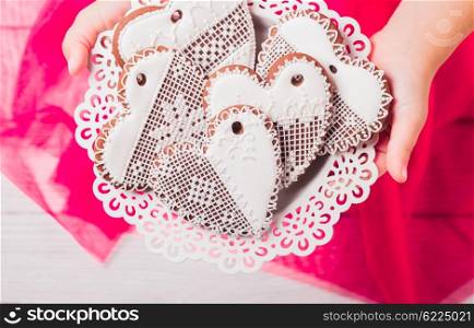 Gingerbread cookies in shape of heart in girl&amp;#39;s hands
