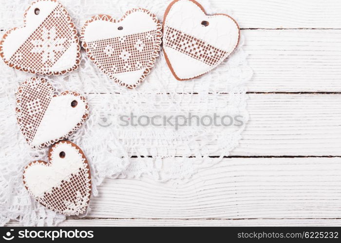 Gingerbread cookies in shape of heart with icing on a crochet doily, copy space