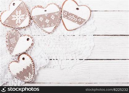 Gingerbread cookies in shape of heart with icing on a crochet doily, copy space