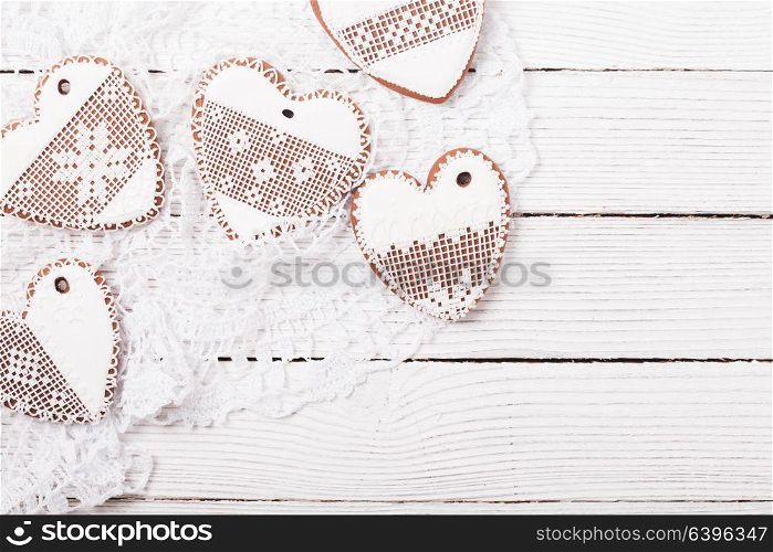Gingerbread cookies in shape of heart with icing on a crochet doily, copy space. Set of homemade cookies