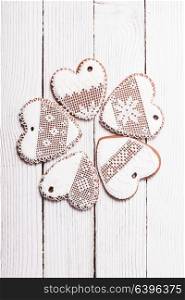 Gingerbread cookies in shape of heart with icing on a wooden background. Set of homemade cookies