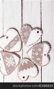 Gingerbread cookies in shape of heart with icing on a wooden background. Set of homemade cookies