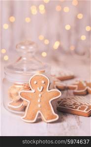 Gingerbread cookies on a table and Christmas lights on background. Gingerbread cookies
